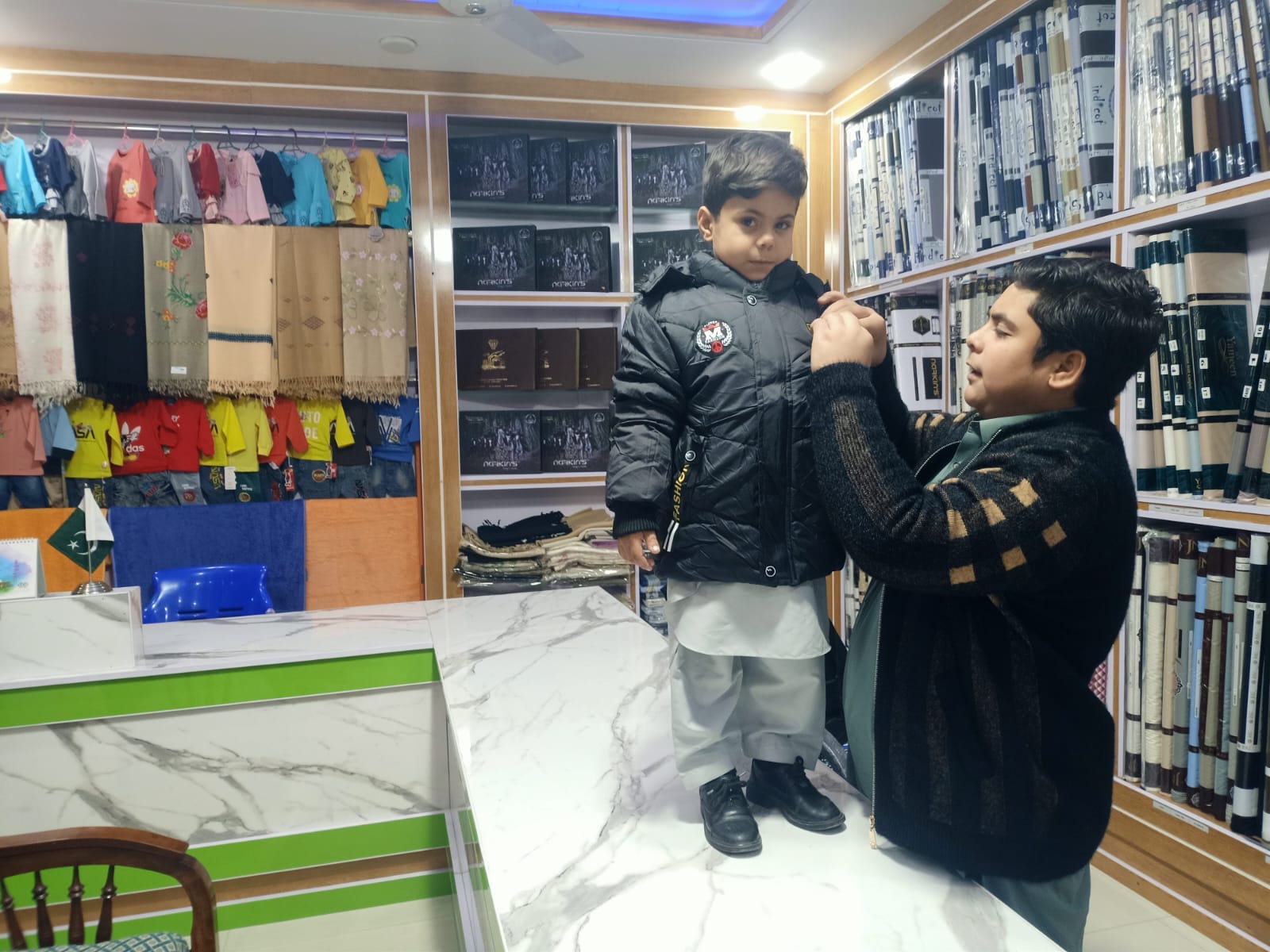 Trying a winter jacket on a child in store